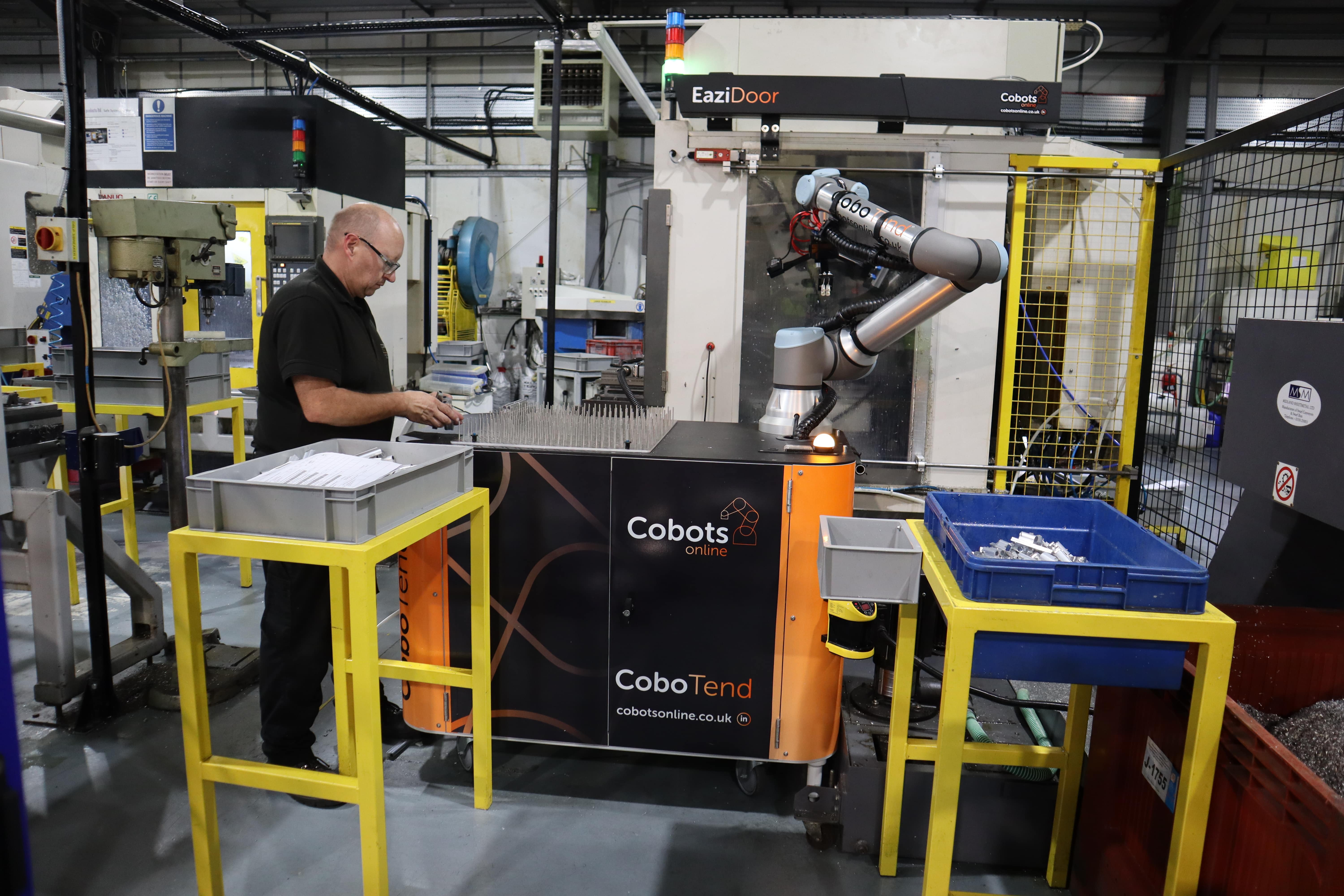 Human working alongside cobot in factory