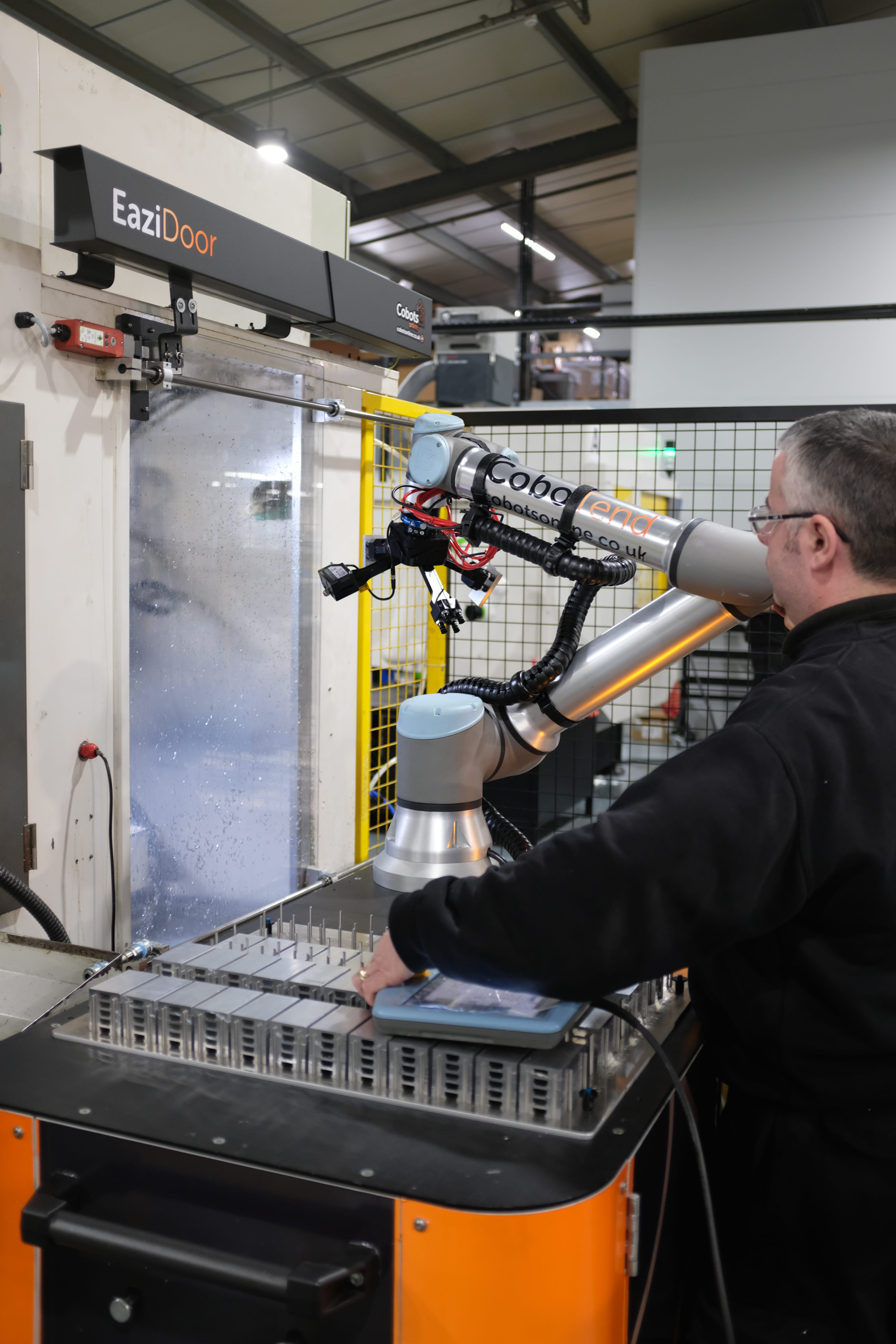 man using pendant to program cobot