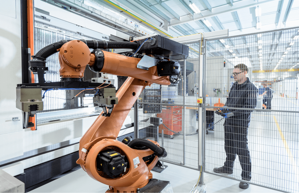 Robot working in factory behind cage